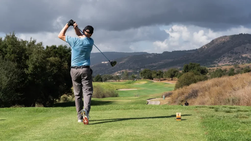 Golfer teeing off on a scenic championship golf course experience with Kentina Hospitality in Temecula Valley
