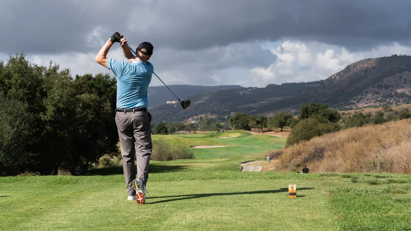 Golfer teeing off on a scenic championship golf course experience with Kentina Hospitality in Temecula Valley
