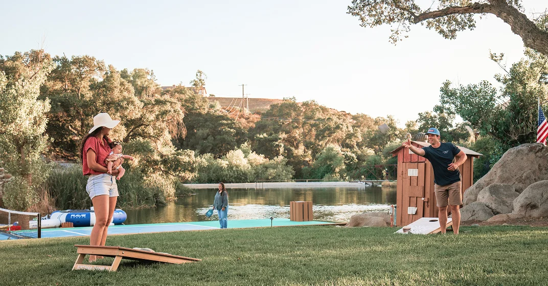 Guests enjoying outdoor lawn games by the lake at a Kentina Hospitality destination in Temecula Valley