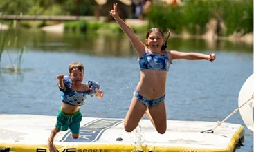 Children enjoying lakeside water activities and outdoor recreation at a Temecula Valley resort with family-friendly waterfront amenities and scenic views
