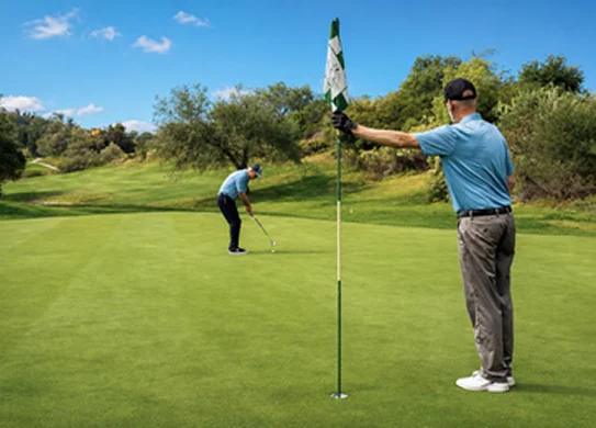 Golfers playing on a championship putting green surrounded by scenic fairways and rolling hills in Temecula Valley