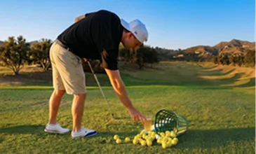Golfer practicing at a scenic driving range in Temecula Valley with rolling hills, championship course views, and professional golf training facilities