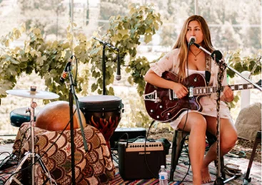 Musician performing live acoustic music during a winery event in Temecula Wine Country, creating a relaxing atmosphere for guests and wine tastings