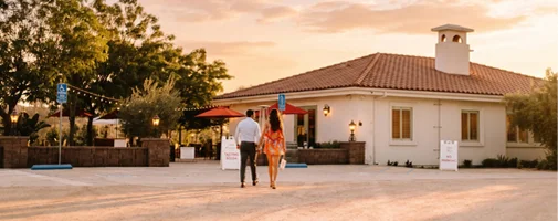 Guests arriving at an elegant winery estate for a wine tasting and hospitality experience in Temecula Wine Country at sunset